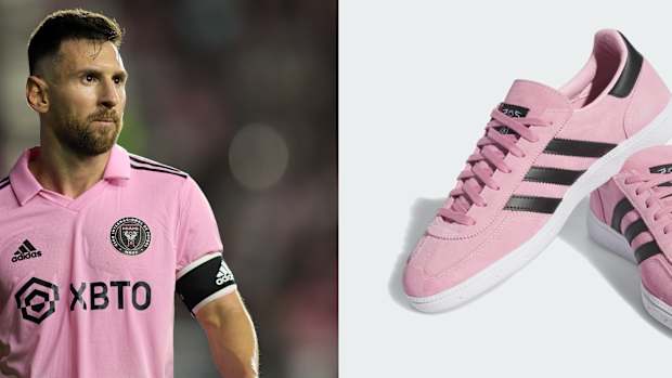Lionel Messi next to his pink and black adidas sneakers.