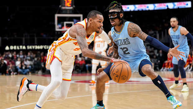 Atlanta Hawks guard Dejounte Murray dribbles past Memphis Grizzlies guard Ja Morant.