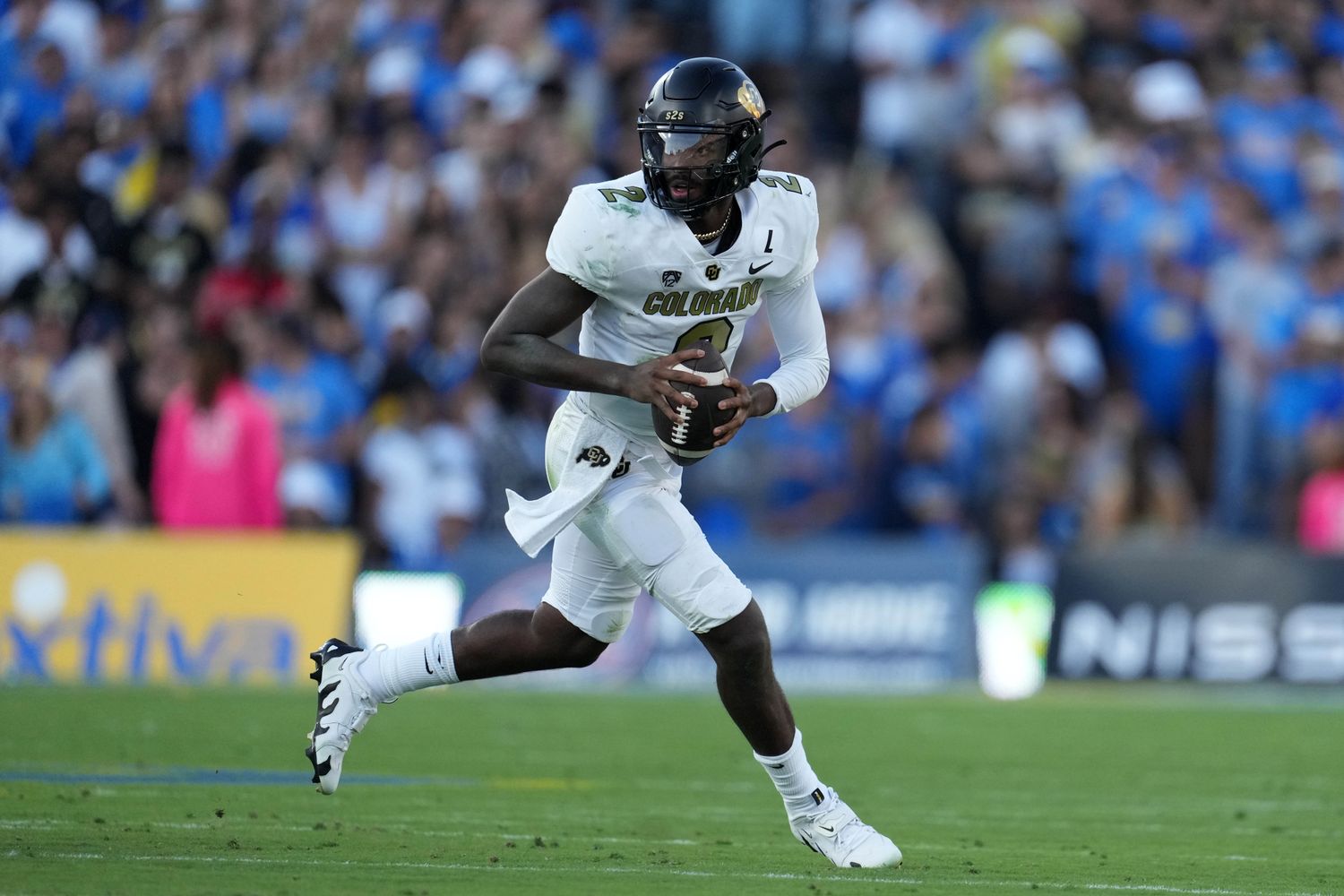 Colorado Buffaloes quarterback Shedeur Sanders runs with the football.