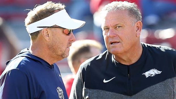 Liberty Flames coach Hugh Freeze talks to Arkansas Razorbacks coach Sam Pittman prior to the game at Razorback Stadium.