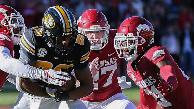 Missouri wide receiver Tauski Dove tries to shake free from Hayden Henry and Montaric Brown against Arkansas in a 2021 loss.