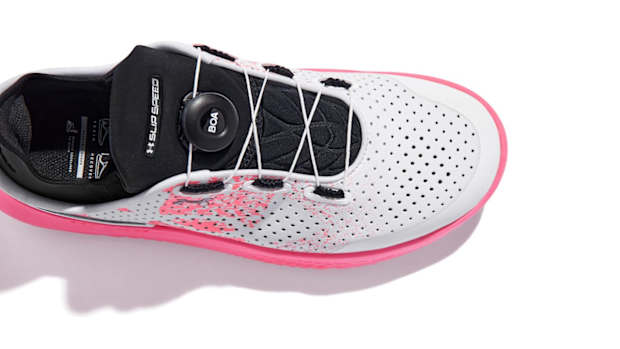 View of black, white, and pink Under Armour shoes.