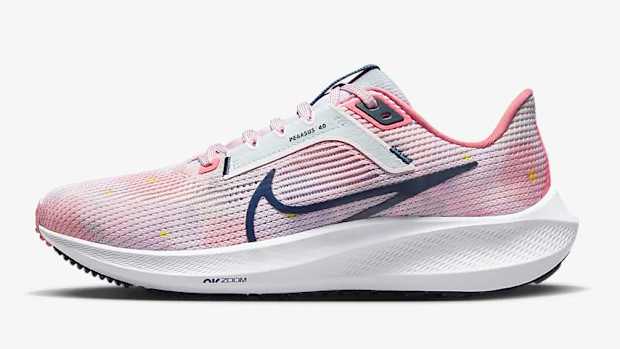 Side view of pink and navy Nike shoe.