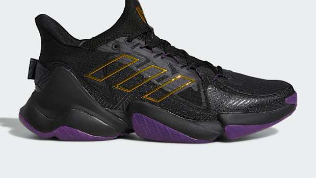 Side view of black and purple Adidas shoe.