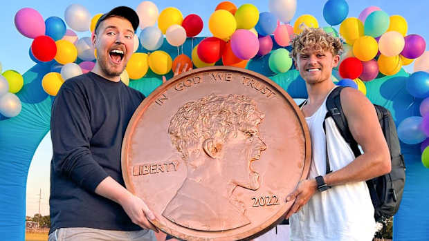 Ryan Trahan presents Mr. Beast with a giant penny.