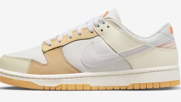 Side view of a white and tan Nike Dunk Low sneaker.