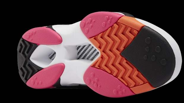 View of white, black, and orange Reebok sneaker outsole.