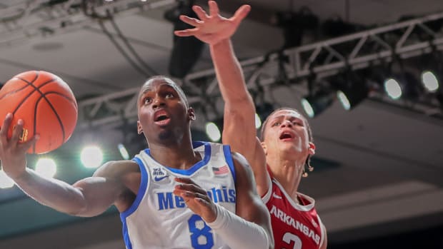 Razorbacks' Trevon Brazile misses a chance for a block against Memphis' David Jones, who scored 36 in the game.