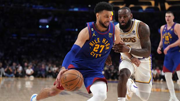 Denver Nuggets guard Jamal Murray dribbles past Los Angeles Lakers forward LeBron James.