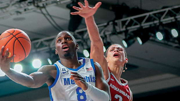 Razorbacks' Trevon Brazile misses a chance for a block against Memphis' David Jones, who scored 36 in the game.