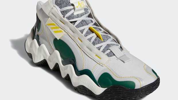 View of white and green adidas basketball shoes.