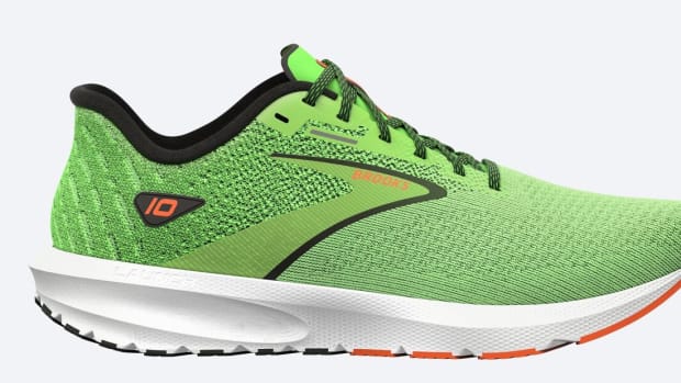 Side view of a green and white Brooks running shoe.