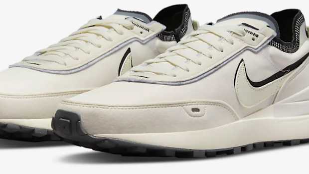 View of tan and black Nike shoes.