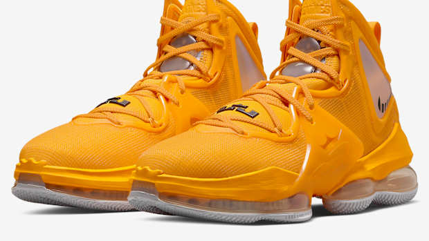 Side view of yellow and black Nike LeBron shoes.