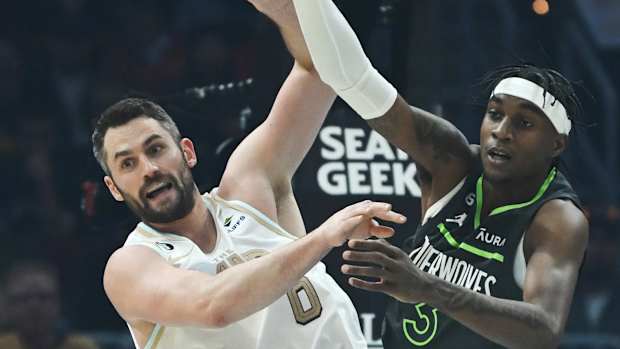 Cleveland Cavaliers forward Kevin Love (0) and Minnesota Timberwolves forward Jaden McDaniels (3) go for a rebound during the first quarter at Rocket Mortgage FieldHouse.