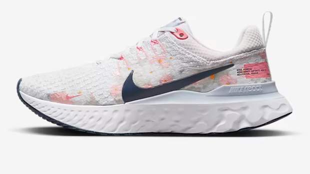Side view of white and Navy Nike shoe.