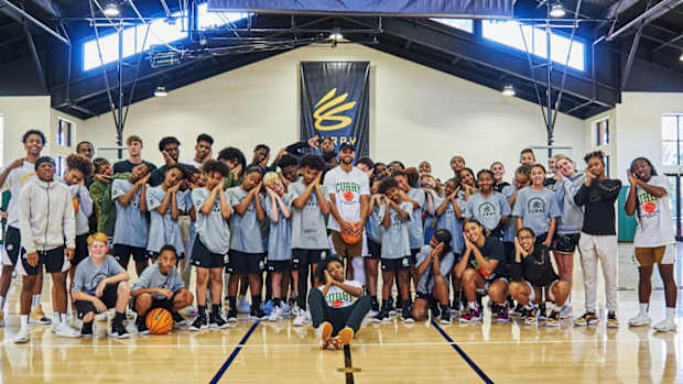 Stephen Curry poses with kids at his basketball camp.