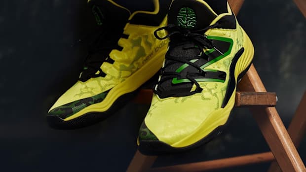 View of yellow, green, and black New Balance shoes.