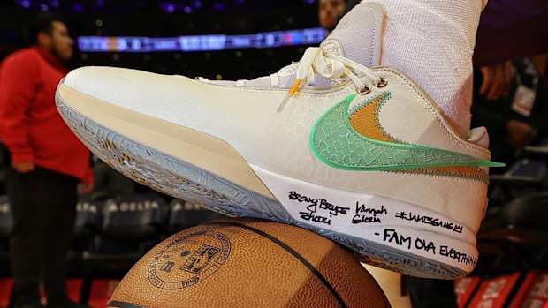 View of white and green Nike LeBron shoe.
