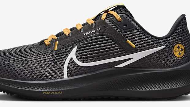 Side view of black and yellow Nike running shoes.