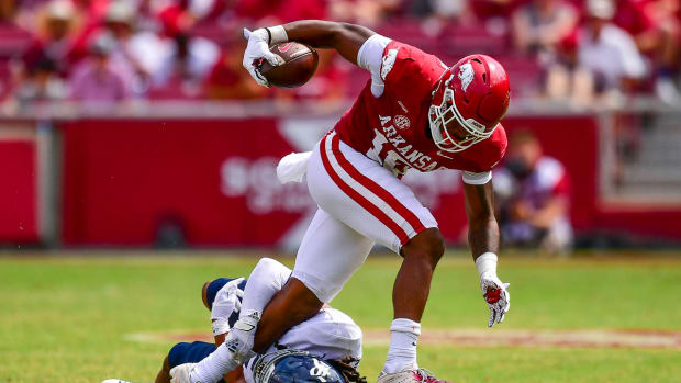 Arkansas wide receiver Treylon Burks breaks the grasp of a Rice defensive back.