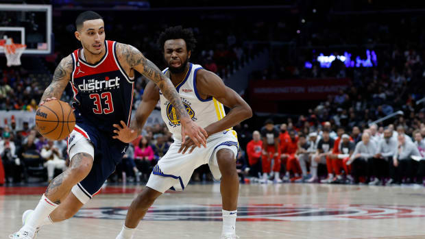 Washington Wizards forward Kyle Kuzma (33) drives against a Golden State Warriors defender.