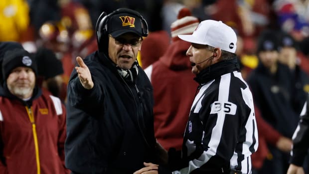 Washington Commanders coach Ron Rivera discusses a play with an NFL official.