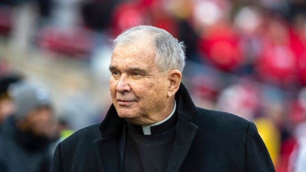 Father Mike walking on the field of Camp Randall Stadium.