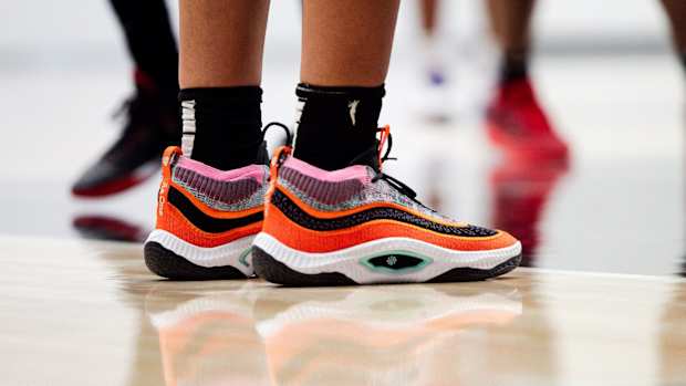 View of orange and black Nike shoes.