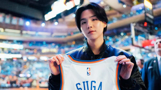 Suga holds up a Knicks jersey before a game.