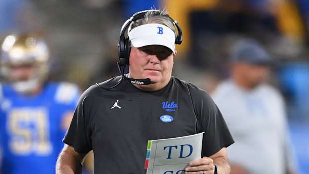 Chip Kelly holds a notebook