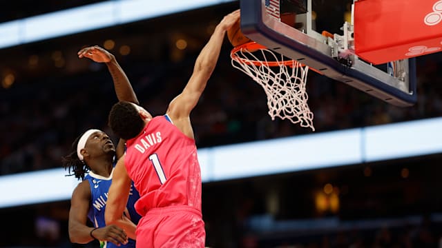 Washington Wizards guard Johnny Davis (1) dunks on Milwaukee Bucks guard Jrue Holiday.