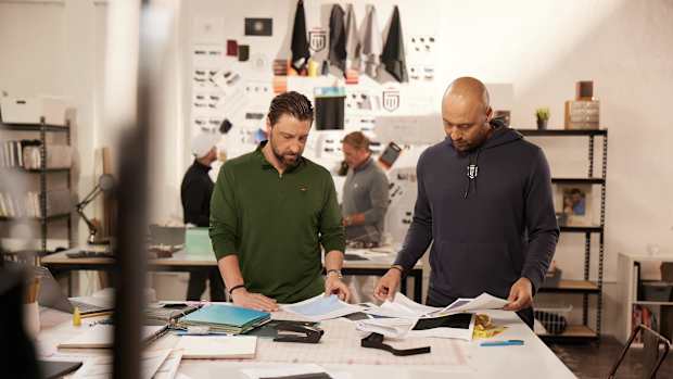 Chris Riccobono and Derek Jeter look over papers.