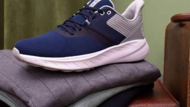 Side view of navy and white Footjoy golf shoes.