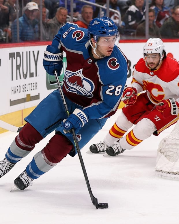Mar 13, 2022; Denver, Colorado, USA; Colorado Avalanche defenseman Ryan Murray (28) controls the puck ahead of Calgary Flames left wing Johnny Gaudreau (13) in the first period at Ball Arena. Mandatory Credit: Isaiah J. Downing-USA TODAY Sports