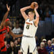 Toronto Raptors forward Precious Achiuwa (5) guards Denver Nuggets center Nikola Jokic (15) during the third quarter at Ball Arena