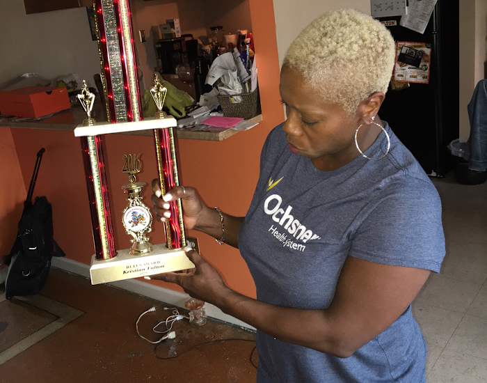 Michelle Fulton, Kristian’s mother, holds a trophy her son won as a senior in high school.