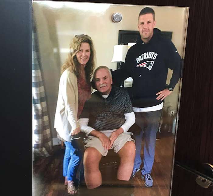 Billy Napier, far right, poses with his father, Bill, and mother, Pam, for a photograph that sits framed in his office.