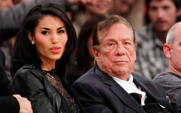 Dec. 19, 2010, file photo, Los Angeles Clippers owner Donald Sterling, third right, sits with V. Stiviano, left, as they watch the Clippers play the Los Angeles Lakers during an NBA preseason basketball game in Los Angeles. NBA commissioner Adam Silver announced Tuesday, April 29, 2014, that he is banning the owner for life from the Clippers organization over racist comments in recording. (AP Photo/Danny Moloshok, File)