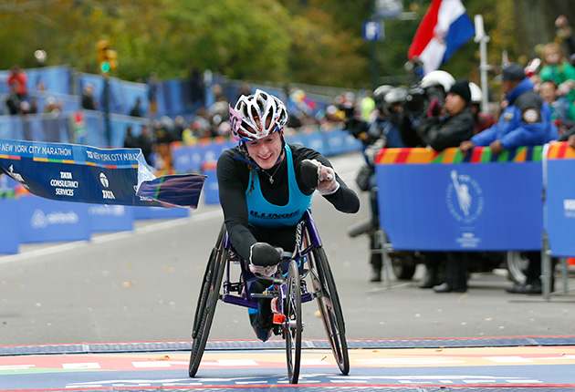 Tatyana McFadden breaks the tape after finishing first in the Women's wheelchair division of the 44th annual New York City Marathon.