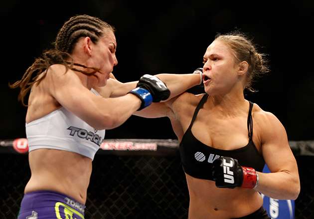 From right to left, UFC Women's Bantamweight champion Ronda Rousey punches Alexis Davis in their title fight at UFC 175 inside the Mandalay Bay Events Center in Las Vegas, Nevada.