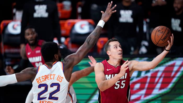 Miami Heat's Duncan Robinson goes to the basket as Phoenix Suns' Deandre Ayton defends