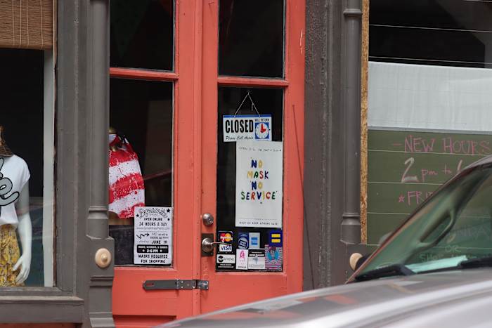 Boutique shop displays "No maks, no service" sign downtown in Athens