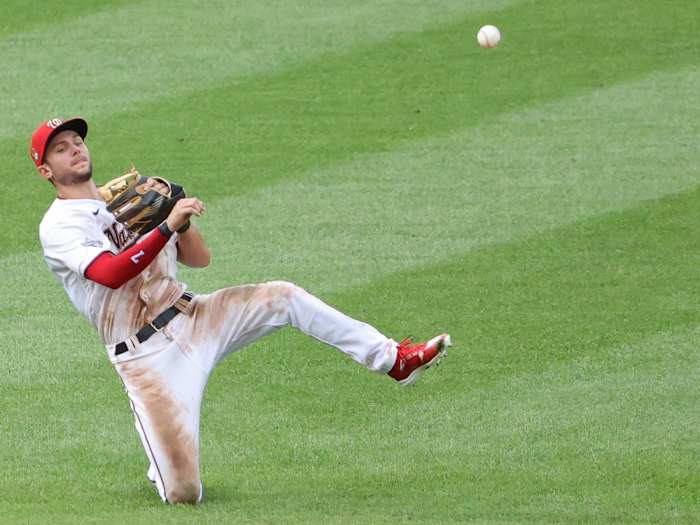 Trea Turner throws from a knee
