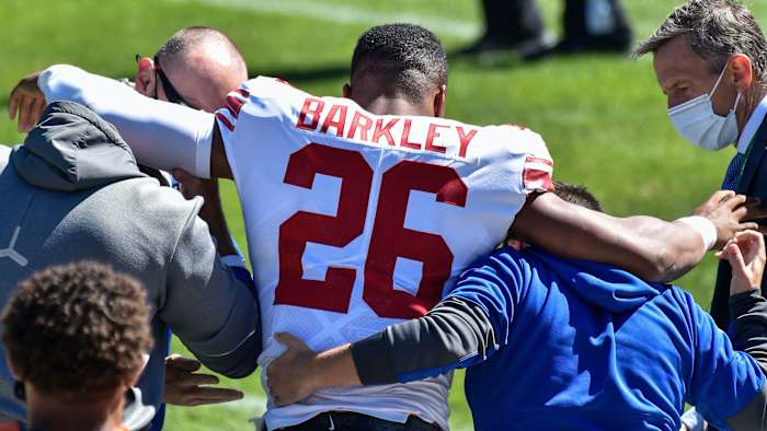 New York Giants running back Saquon Barkley (26) is helped off of the field after suffering an injury during the second quarter against the Chicago Bears at Soldier Field.