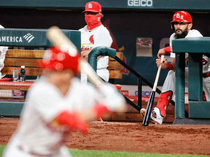 Two people stand in the Cardinals dugout