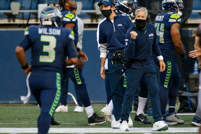 Seahawks head coach Pete Carroll wears his neck gaiter as he cheers on quarterback Russell Wilson.