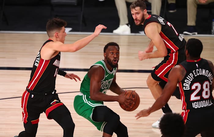 Boston Celtics guard Kemba Walker (middle) drives against Miami Heat guard Tyler Herro (left) and guard Andre Iguodala (28) and guard Goran Dragic (7)