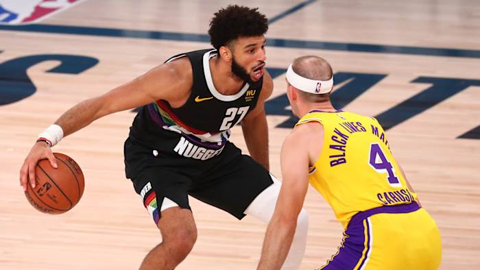 Nuggets guard Jamal Murray dribbles the ball around Los Angeles Lakers guard Alex Caruso