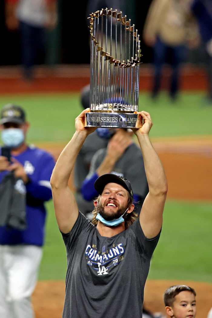 Oct 27, 2020; Arlington, Texas, USA; Los Angeles Dodgers starting pitcher Clayton Kershaw (22) celebrates with the Commissioner's Trophy after the Los Angeles Dodgers beat the Tampa Bay Rays to win the World Series in game six of the 2020 World Series at Globe Life Field. Mandatory Credit: Tim Heitman-USA TODAY Sports